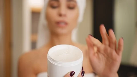 Woman using moisturizing cream on her face, skincare routine Stock Footage 101484706