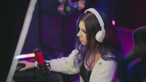 Woman using mouse in gaming setup with condenser mic and headphones Video stock 307459039