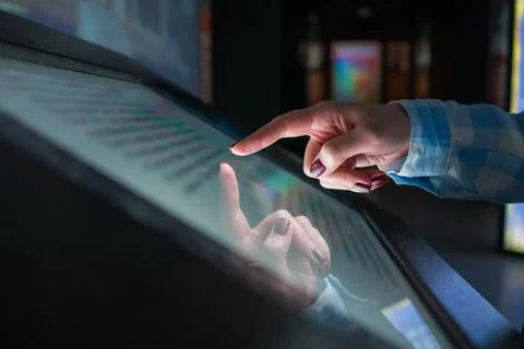 Woman using multimedia touchscreen display of interactive kiosk Stock Photos