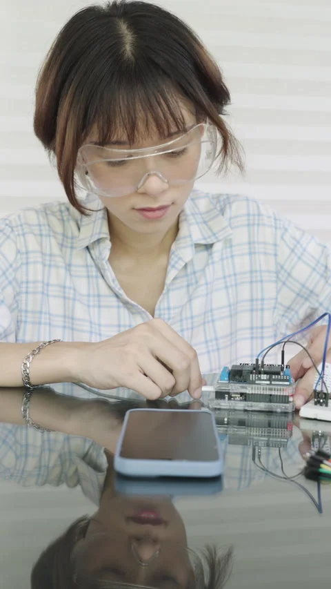 Woman is using a multimeter to check the microcontroller's functionality. Video stock 334764452