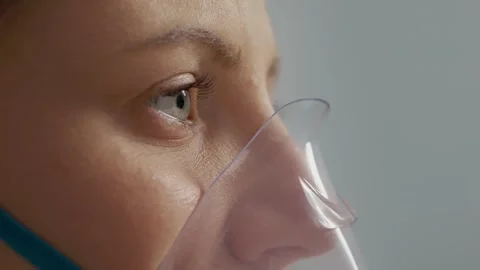 Woman using a nebulizer to inhale solution for cough and respiratory treatment Stock Footage 346706123