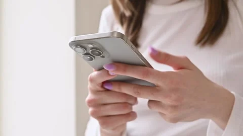 Woman using a new mobile iphone 15 close-up, holding cellphone in hands 스톡 동영상 273827242