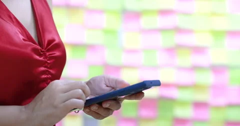 Woman using or typing messages on smartphone, colorful sticky notes background Video stock 334127723