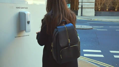 Woman using an outdoors sanitisation point during pandemic coronavirus covid-19. Stock Footage 147310335