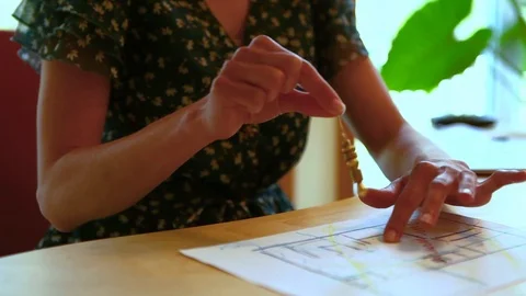 Woman using a pendulum over a house plan Stock Footage 92394962