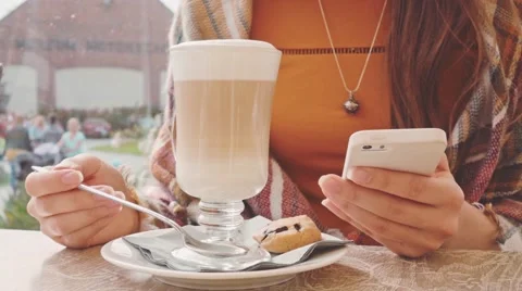 Woman using phone and drinking coffee outdoors, close up. Slow Motion 120 fps. Stock Footage 67231314