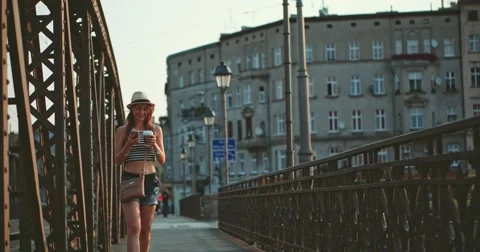 Woman using phone, drinking coffee, walking in the European city. Slow Motion. Видео 53458911