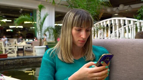 Woman using phone sitting at table in cafe Video stock 89227852