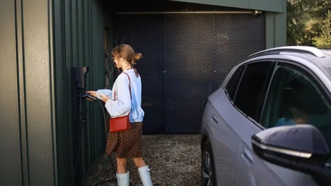 Woman Using Phone While Charging Electric Car Stock Footage 282965762