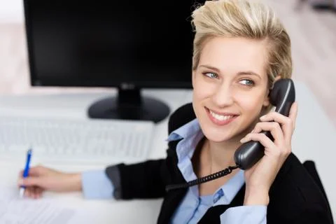 Woman using phone while looking up in office Stock Photos