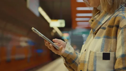 Woman using phone while waiting for subway Stock Footage 302473594