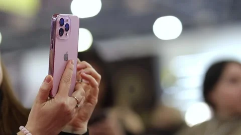 Woman using pink 14 pro iphone, close up shot, blurred background. Stock Footage 277607907