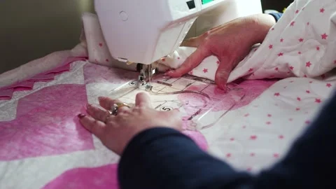 Woman using a plastic template and a sewing machine to stitch a pattern on Stock Footage 168421062