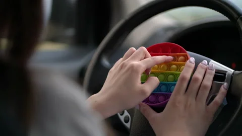 Woman using pop it or simple dimple in car. Stock Footage 155541765