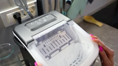 Woman Using Portable Ice Maker Machine on Kitchen Countertop Stock Footage 339375706