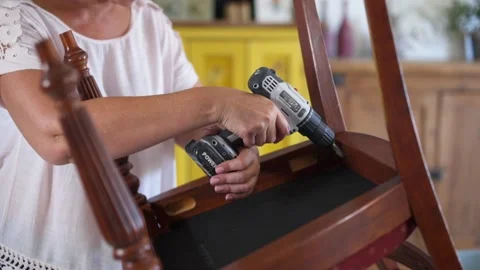 Woman using power tool to fix broken antique furniture Stock Footage 130912050