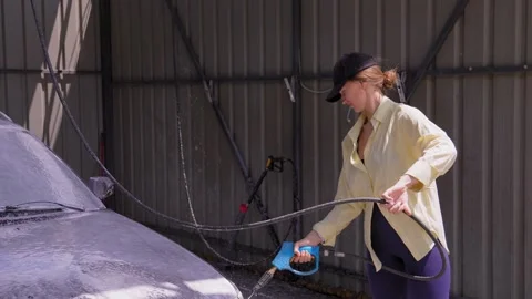 Woman using pressure washer at self service car wash Stock Footage 344001620