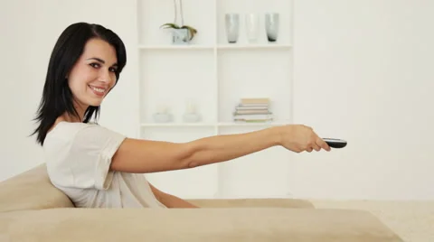 Woman Using Remote Control To Change TV Channel Stock Footage 921493