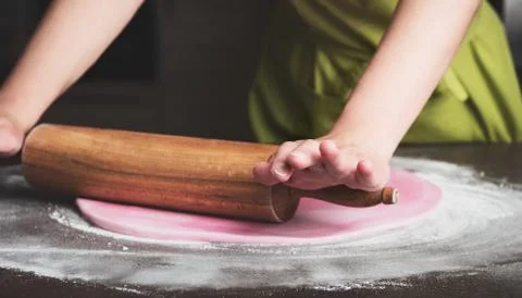 Woman using rolling pin preparing royal icing for cake decorating, hands deta Stock Photos