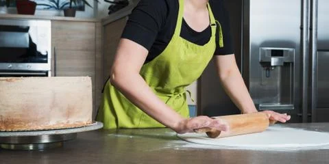 Woman using rolling pin preparing white fondant for cake decorating, hands de 스톡 사진