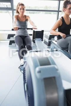 Woman using rowing machine Stock Photos