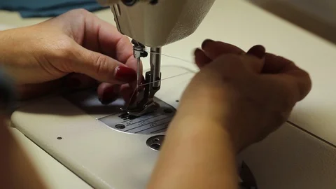 Woman using a sewing machine makes protective masks from cotton fabric. Stock Footage 127840362