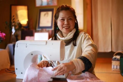 Woman using a sewing machine Stock Photos