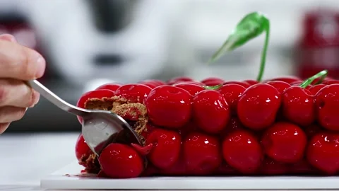 Woman using small spoon to cut pieces from modern 3d cake, close shot of plate Video stock 148599471