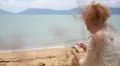 Woman Using Smart Phone on the Beach. HD Footage