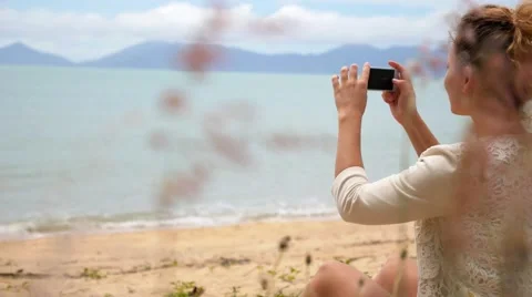 Woman Using Smart Phone to Take Photo on Beach. Видео 40748465