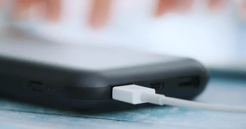 Woman using smart phone while charging on the power bank. Closeup. Stock Footage 102724112