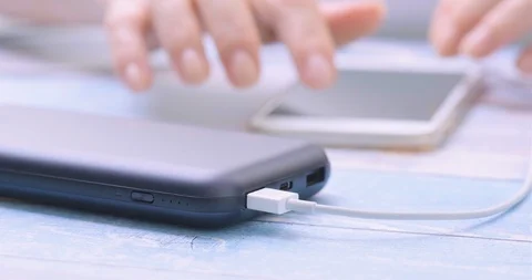 Woman using smart phone while charging on the power bank. Stock Footage 102727638
