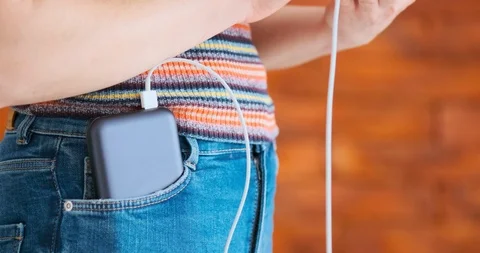 Woman using smart phone while charging on the power bank. 動画素材 103251480