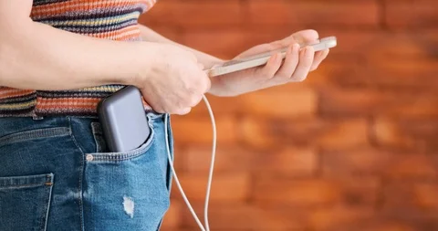 Woman using smart phone while charging on the power bank. Stock Footage 103251482