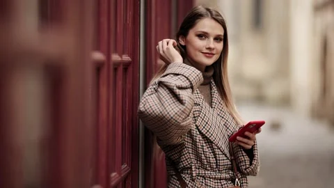 Woman using smart phone while standing outdoors on a city street. Attractive Vídeo Stock 151772380
