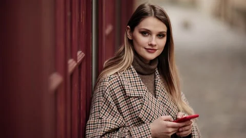 Woman using smart phone while standing outdoors on a city street. Attractive Stock Footage 151858147