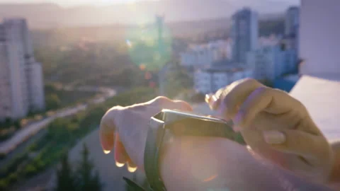 Woman using smart watch at sunset on the balcony close-up, cinematic Stock Footage 207495747