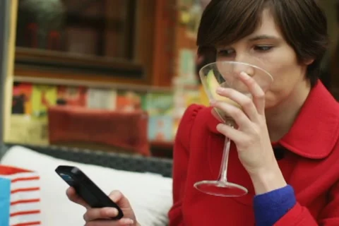 Woman using smartphone and drinking cocktail, steadicam shot NTSC Video stock 10896095