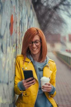 Woman using smartphone and drinking coffee Stock Photos