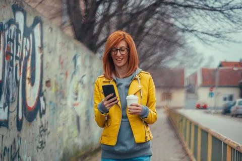 Woman using smartphone and drinking coffee Stock Photos
