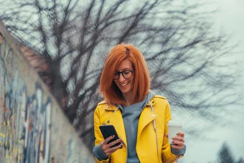 Woman using smartphone and drinking coffee Stock Photos