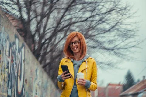 Woman using smartphone and drinking coffee Stock Photos