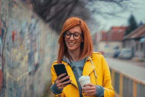 Woman using smartphone and drinking coffee Stock Photos
