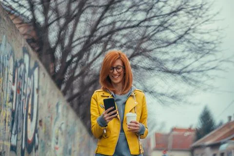 Woman using smartphone and drinking coffee Stock Photos