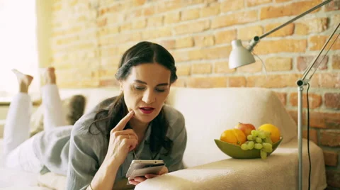 Woman using smartphone and lying on the sofa Vídeos de archivo 50526014