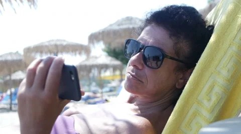 Woman using smartphone on the beach Stock Footage 65220300