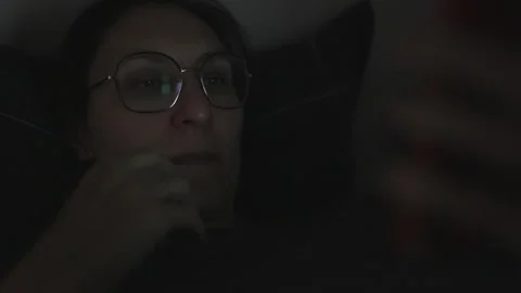 Woman using smartphone in bed at night Stock Footage 311433944