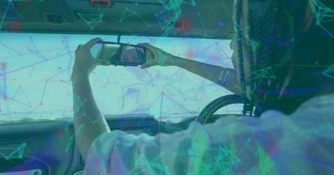 Woman using smartphone checking reflection in cabin, sun visor mirror, steering Fotos de archivo