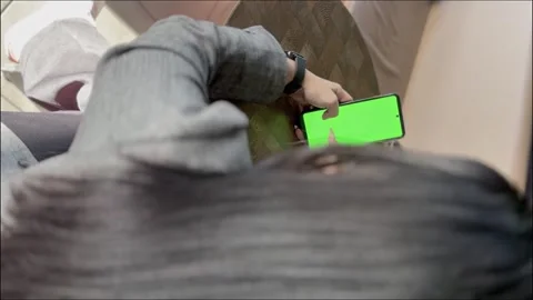 Woman Using Smartphone with Chroma Key While Relaxing Outdoors Stock Footage 307796929