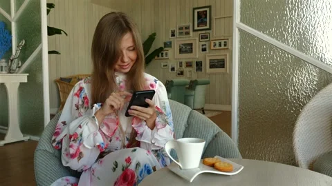 Woman using smartphone during coffee break in cozy home interior. Modern Stock-Footage 263233178